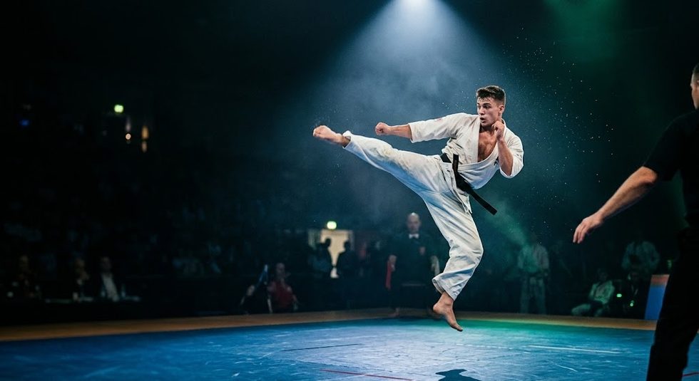 Martial arts tournament competitor mid-kick